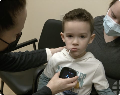 boy using TytoCare device